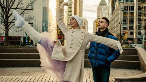 Two dancers dressed for cold weather, dance on the streets of New York City.